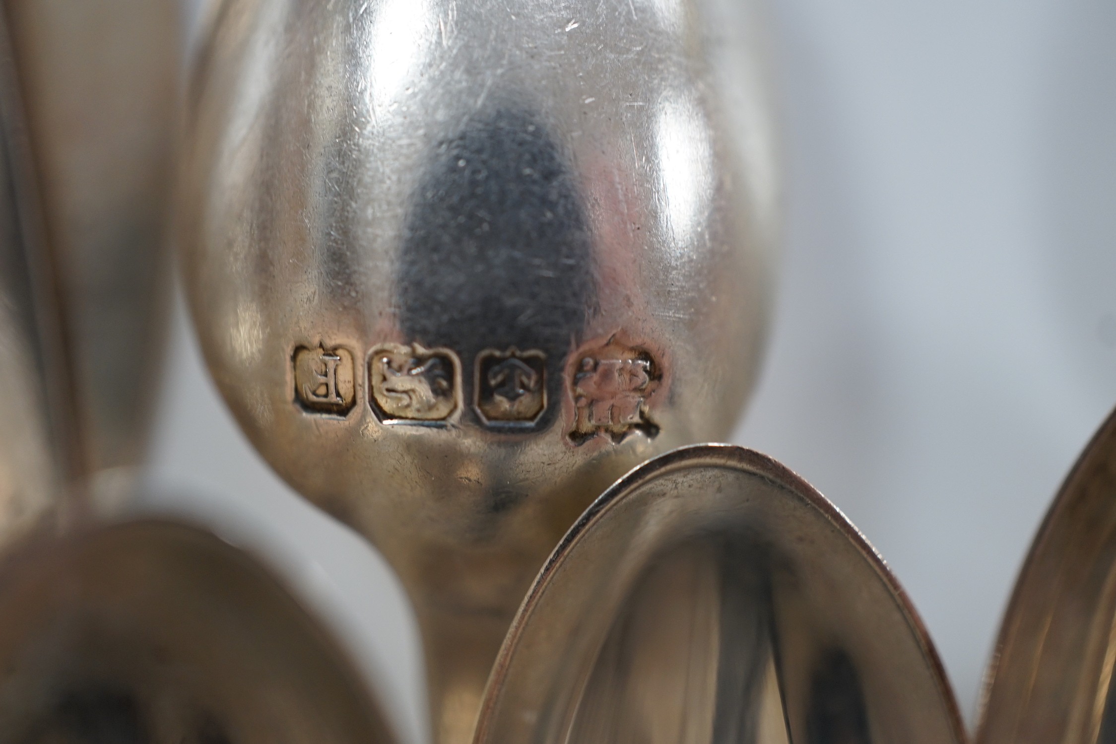 A small collection of assorted silver flatware including teaspoons, enamelled spoons(a.f.), butter knives, pastry forks and a pair of continental 830 white metal cake tongs, gross weight 14.4 oz.